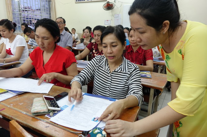 Cô Phan Hải Yến (Trường THCS Lý Phong, Q.5, TP.HCM) hướng dẫn phụ huynh lớp 9A1 ghi hồ sơ tuyển sinh lớp 10 vào tối 5-5-2016 - Ảnh: Như Hùng
