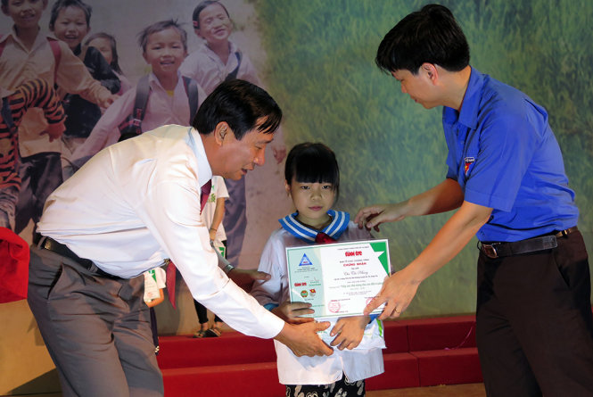 Ông Đỗ Thế Hưng - đại diện Ban biên tập báo Tuổi Trẻ (bìa trái) và đại diện Tỉnh đoàn Hưng Yên trao quà cho học sinh nghèo vượt khó - Ảnh: QUANG THẾ