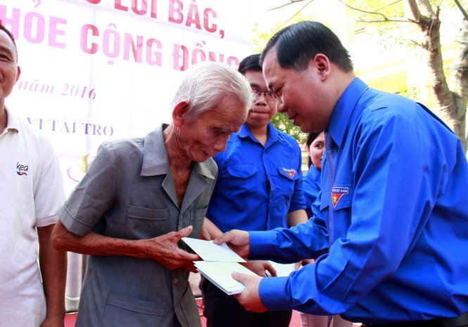 Anh Nguyễn Phi Long tặng quà cho người dân có hoàn cảnh khó khăn trong ngày hội - Ảnh: XUÂN AN