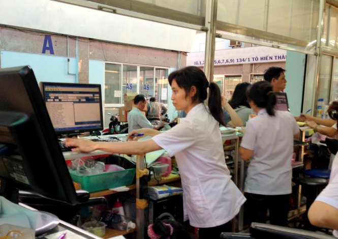 Nhân viên bán thuốc đang tìm tên thuốc trên hệ thống máy tính của cửa hàng - Ảnh: Minh Huyền