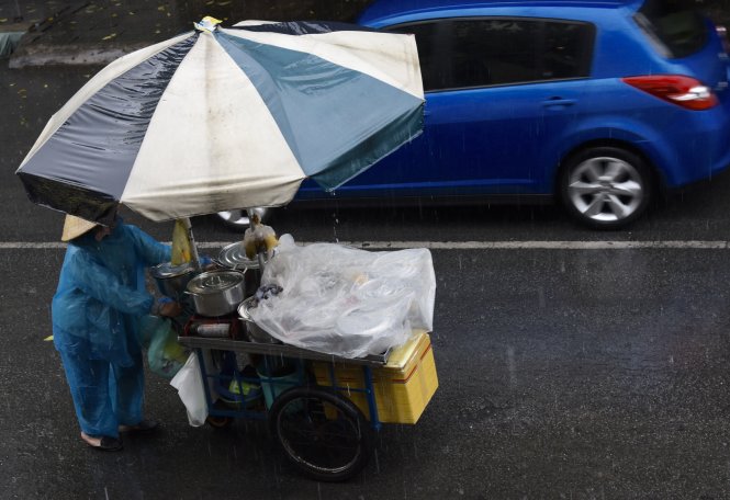 Gánh hàng rong trong cơn mưa chiều 16-5 trên đường Hoa Phượng, Hoa Mai Q.Phú Nhuận, TP.HCM - Ảnh: Tự Trung