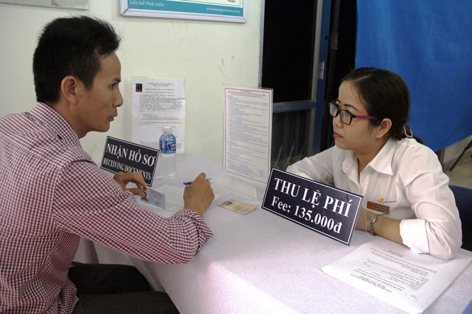 Nhân viên bưu điện Bình Chánh hướng dẫn người dân làm hồ sơ cấp đổi GPLX.