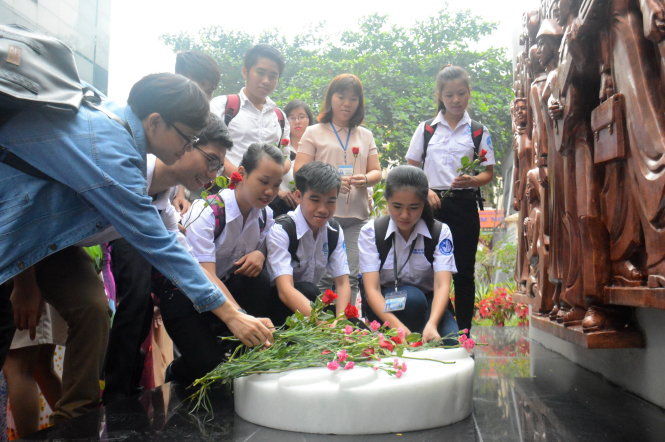 Sinh viên dâng hoa trước công trình - Ảnh: C.Tiên