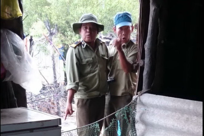 Hai nhân viên bảo vệ rừng thuộc Ban quản lý rừng phòng hộ Long Thành (Đồng Nai) đang đe dọa gia đình bà Ngọc - Ảnh: cắt từ clip