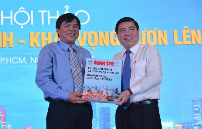 Ông Tăng Hữu Phong (trái) - Tổng biên tập báo Tuổi Trẻ - trao 9.500 ý kiến của bạn đọc cho ông Nguyễn Thành Phong - Chủ tịch UBND TP.HCM tại hội thảo - Ảnh: Quang Định