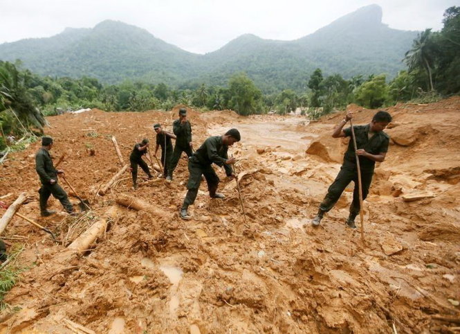 Công tác cứu hộ gặp nhiều khó khăn do mưa lớn và bùn sâu - Ảnh: Reuters
