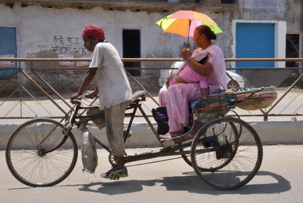 Một người chạy xe xích lô ở Amritsar, Ấn Độ đạp xe dưới trời nắng gắt - Ảnh: AFP