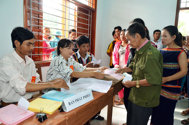 Các cử tri làng Kon Lót nhận phiếu bầu cử - Ảnh: HOA KHÁ