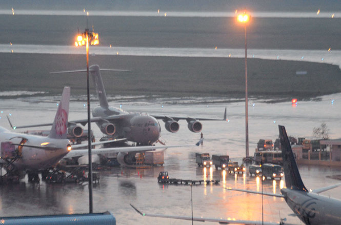 Đoàn xe chở các trang thiết bị di chuyển khỏi sân bay Tân Sơn Nhất trong cơn mưa chiều. Ảnh: Hữu Khoa
