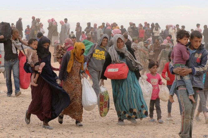 Người tị nạn Syria tay xách nách mang đồ đoàn chờ được thông quan vào Jordan tại vùng biên giới Hadalat - Ảnh: AFP