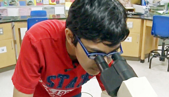 Tanishq Abraham dùng kính hiển vi tại Cao đẳng cộng đồng America River, bang California, Mỹ - Ảnh: AP