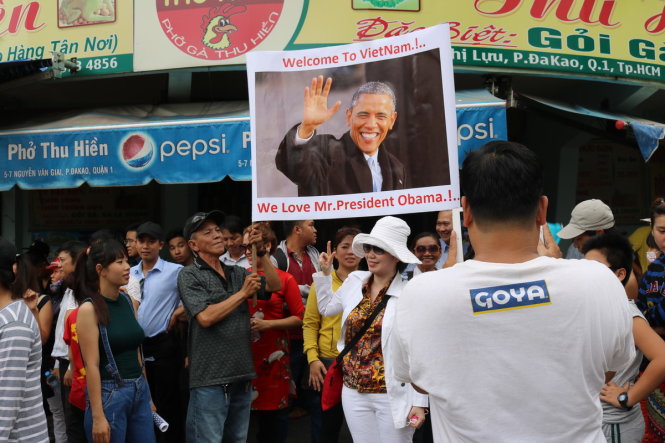 Người nhà anh Vinh giơ bannner chào đón Tổng thống Mỹ Barack Obama, còn anh Vinh tranh thủ chụp ảnh lại cho người thân
