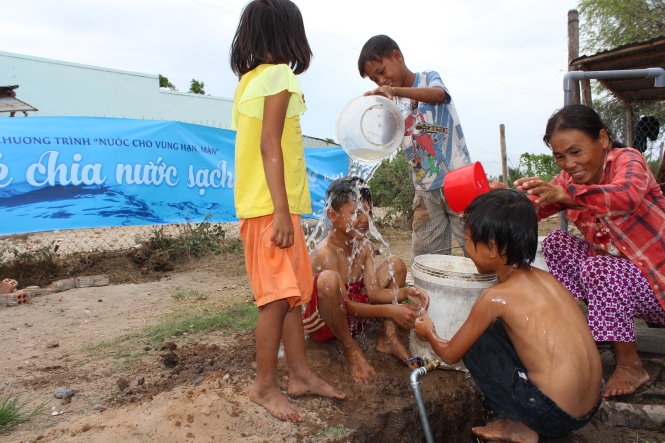 Chị Nguyễn Thị Mỹ Dung cùng các con vui mừng đón nguồn nước mát từ chiến dịch “Sẻ chia nước sạch” - Ảnh: Minh Trần