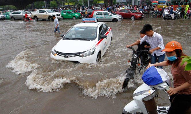 Ngập lớn tại ngã ba Phạm Hùng - Nguyễn Hoàng khiến nhiều phương tiện di chuyển khó khăn - Ảnh: NAM TRẦN