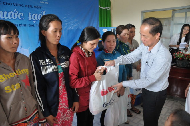 Ông Lê Xuân Trung – phó tổng biên tập báo Tuổi Trẻ tặng quà  cho bà con vùng hạn, mặn Bến Tre- Ảnh: Thanh Tú