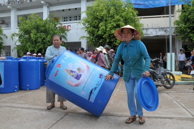 Người dân xã Thừa Đức, huyện Bình Đại, tỉnh Bến Tre phấn khởi nhận bồn chứa nước - Ảnh: Thanh Tú