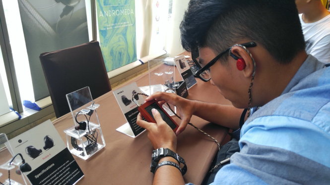 Một bạn trẻ thử tai nghe gắn trong (earphone) Noble 4 tại triển lãm P.A.S 2016 (Tp.HCM) - Ảnh: T.Trực