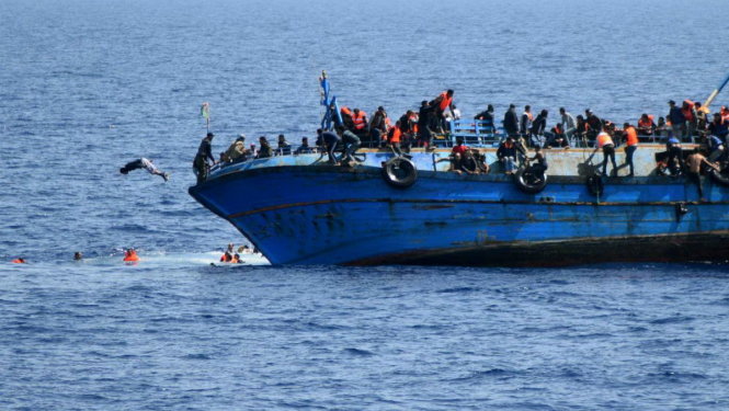 Người di cư nhảy khỏi một con tàu sắp chìm ngoài khơi Libya - Ảnh: Independent