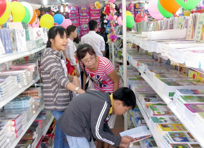 Chị Nguyễn Thị Hương - nhà gần chợ Hóc Môn - tranh thủ dẫn hai con đi hội sách hè từ đầu buổi khai mạc - Ảnh: L.Điền
