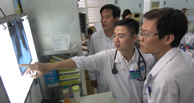 Bác sĩ Minh (giữa) cùng các đồng nghiệp tại Bệnh viện quận Gò Vấp trao đổi một ca bệnh - Ảnh: Hải Hiếu