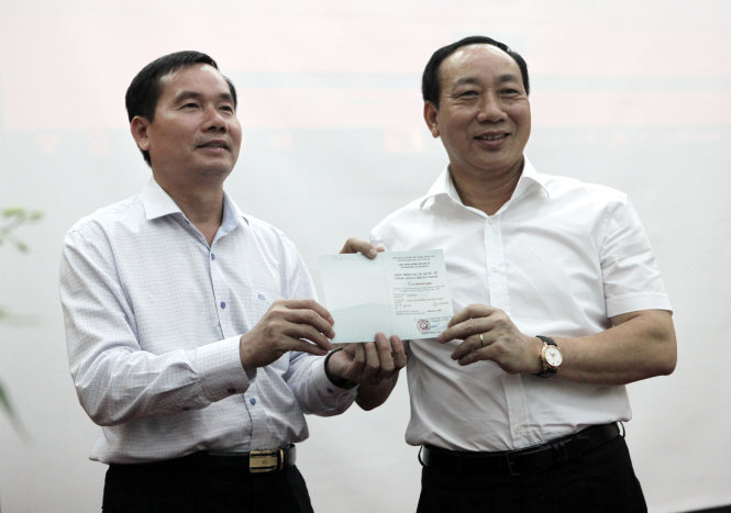 Thứ trưởng Bộ GTVT Nguyễn Hồng Trường (phải) nhận IDP sau khi đăng ký thủ tục cấp qua mạng tại buổi lễ - Ảnh: T.Phùng
