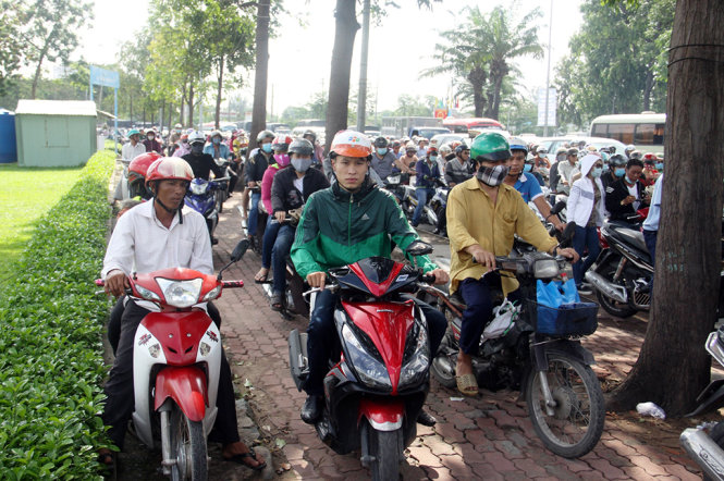 Nhiều người đi xe máy chạy hẳn lên lề đường khiến giao thông qua khu vực càng hỗ loạn - Ảnh: Lê Phan