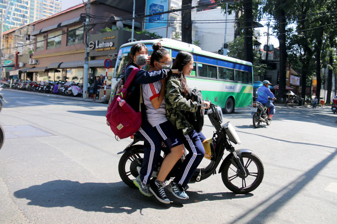Ba nữ sinh không đội mũ bảo hiểm chạy xe điện trên đường Ngô Thời Nhiệm (Q.3, TP.HCM) - Ảnh: NGỌC HIỂN