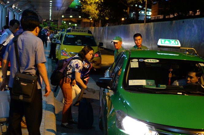 Hành khách đi xe taxi tại sân bay Tân Sơn Nhất - Ảnh: HỮU KHOA