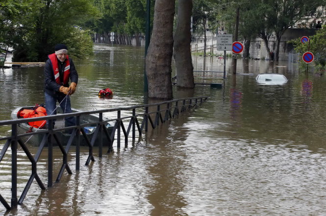 Người dân thủ đô phải sử dụng thuyền cao su di chuyển trong nội ô ngày 3-6 do nước ngập lụt sau nhiều ngày mưa lớn - Ảnh: Reuters