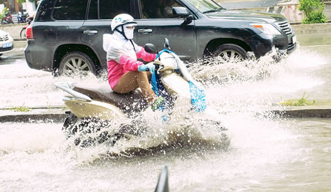 Cơn mưa đầu mùa cùng với triều cường đã khiến nhiều con đường ở TP.HCM bị ngập  - Ảnh: Hoài Linh