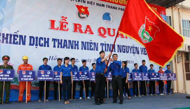 Anh Trần Quang Tường, bí thư thành đoàn TP Hải Phòng (phía trên, bên phải) trao cờ lệnh phát động chiến dịch Thanh niên tình nguyện hè 2016 - Ảnh: TIẾN THẮNG