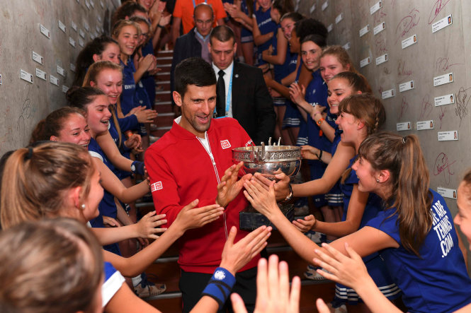 Djokovic chia vui cùng các cô gái nhặt bóng. Ảnh: Reuters