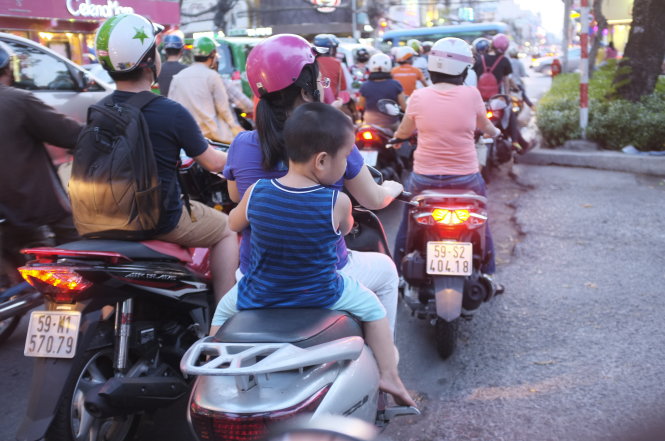 Cho con đội mũ bảo hiểm khi đi đường là vì an toàn của trẻ - 
Ảnh: CHÂU ANH
