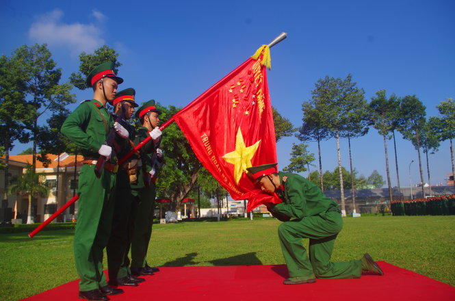 Chiến sĩ mới hôn cờ Tổ quốc trong lễ tuyên thệ - Ảnh: H.Tuấn
