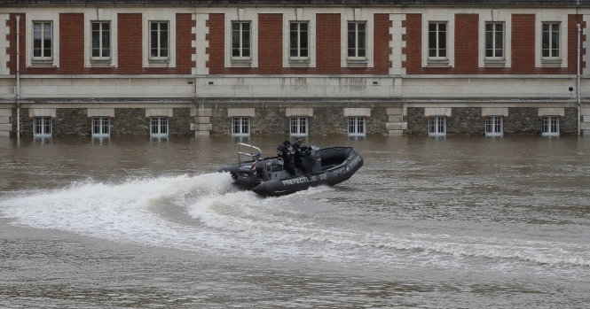 Cảnh sát Paris lái xuồng đi kiểm tra một khu nhà dân bị ngập ở gần nhà thờ Đức Bà bên bờ sông Seine ngày 4-6 - Ảnh: Reuters