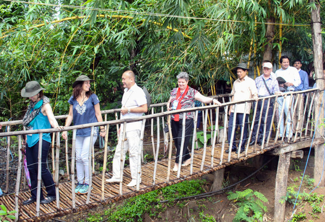 Các đại biểu thích thú khi đi trên cầu treo - Ảnh: Kim Bảo