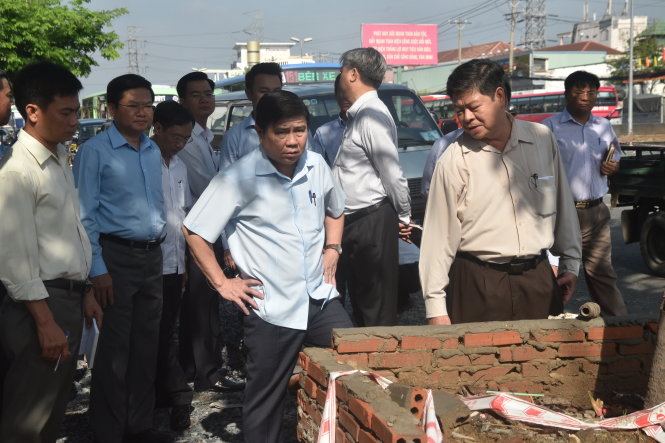 Chủ tịch UBND TP.HCM Nguyễn Thành Phong (trái) thị sát 
hiện trường ở đường Kinh Dương Vương                      - Ảnh: N.H.