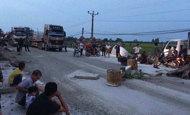 Hàng trăm người dân xã Lương Điền mang bê tông, cành cây ra chắn trên quốc lộ 38 để ngăn xe tải, xe container lưu thông qua vào ngày 10-6 - Ảnh: CTV
