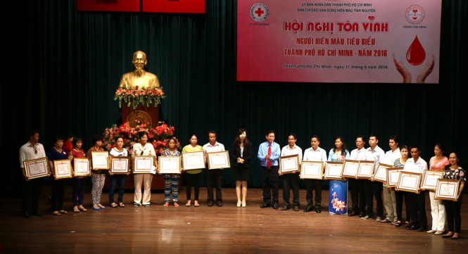 Đại diện Hội Chữ thập đỏ TP.HCM trao bằng khen cho các cá nhân hiến máu tiêu biểu sáng 11-6 - Ảnh: NGỌC DƯƠNG
