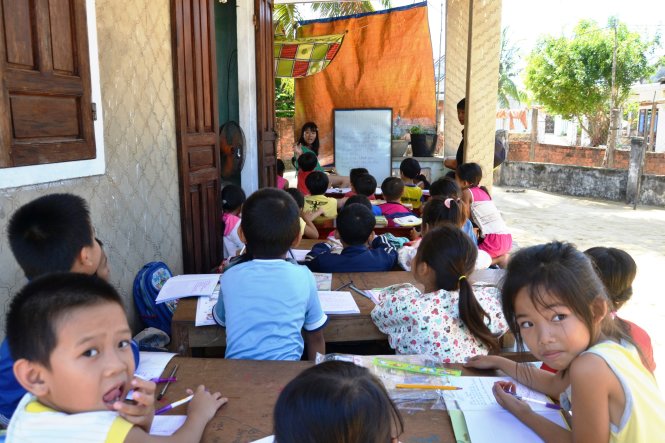 Vương Thị Dung ngồi dạy học cho những đứa trẻ làng Chan Chu - Ảnh: Lê Trung