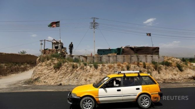 Cảnh sát Afghanistan đứng gác tại một chốt kiểm soát an ninh trên đường cao tốc bắc Kabul - Ảnh: Reuters