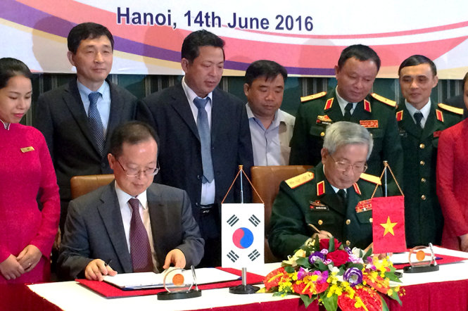 Thượng tướng Nguyễn Chí Vịnh (phải) và ông Change Jae Yun ký kết biên bản hợp tác khắc phục hậu quả bom mìn sau chiến tranh. Ảnh: Q.TR.