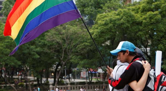 Hai thành viên cộng đồng người đồng tính ở Mexico City an ủi nhau tại lễ tưởng niệm nạn nhân vụ xả súng ở Orlando, Florida - Ảnh: Reuters