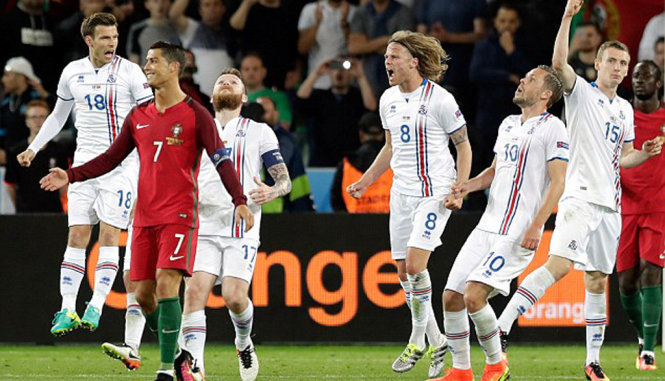 Ronaldo thất vọng trong khi các cầu thủ Iceland vui mừng sau khi trận đấu kết thúc - Ảnh: AP