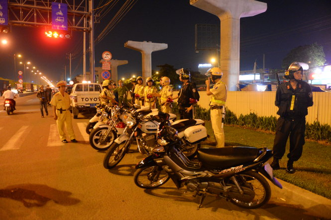 Tổ công tác liên ngành gồm cảnh sát giao thông, cảnh sát cơ động, công an khu vực và dân phòng lập chốt kiểm tra trong đêm trên xa lộ Hà Nội, Q.Thủ Đức, TP.HCM - Ảnh: Hữu Khoa