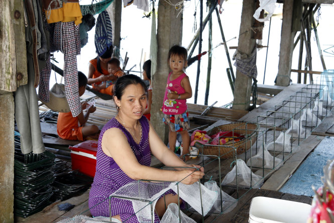 Chị Hà Thị Mến làm lưới lừ bên căn nhà chồ để nuôi sáu người con - Ảnh: Thái Lộc