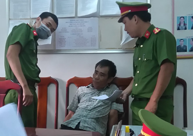 Cơ quan công an tống đạt quyết định khởi tố bị can và bắt tạm giam đối với ông Hùng - Ảnh: Đoàn Cường