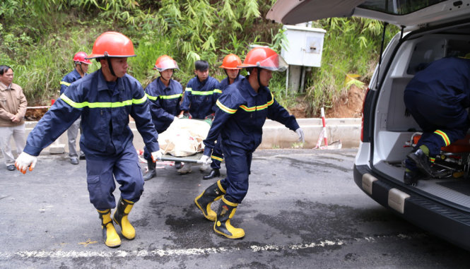 Đội cứu hộ khẩn trương đưa những người tử vong từ xe khách 32 chỗ lên xe cứu thương - Ảnh: CHÍNH THÀNH