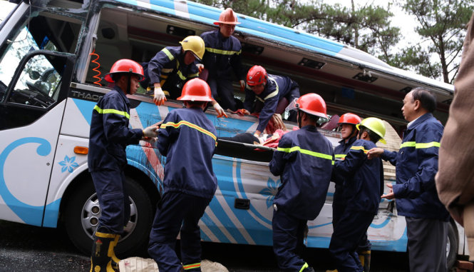 Đội cứu hộ khẩn trương đưa những người tử vong từ xe khách 32 chỗ lên xe cứu thương - Ảnh: CHÍNH THÀNH