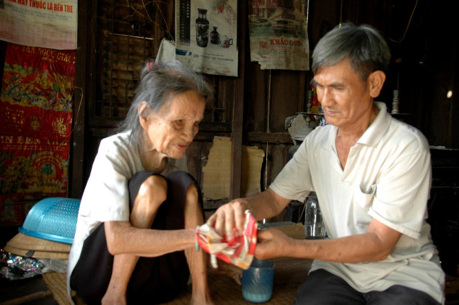 Ông Trương Minh Thái chăm sóc cụ Thời - Ảnh: Lư thế Nhã